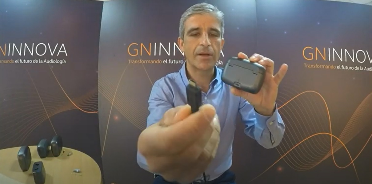 Jefe de producto en ReSound España mostrando nuevo puerto de conexión en cargadores GN 