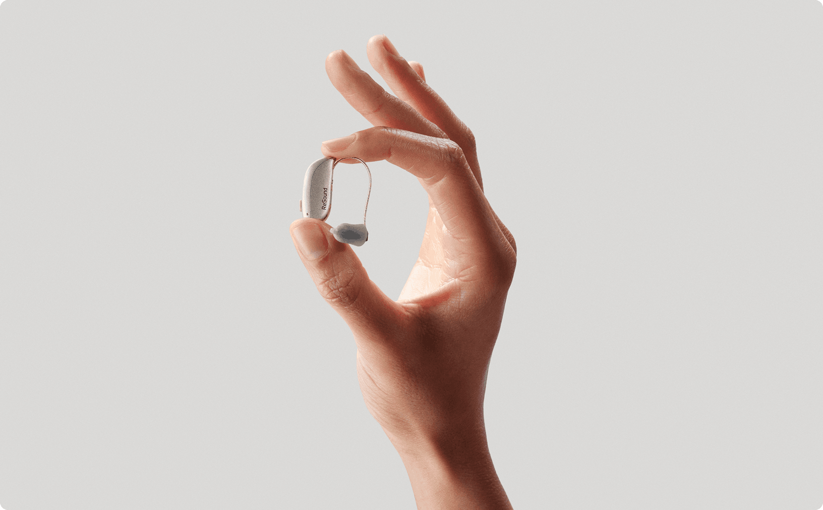 Hand holding ReSound Sensia hearing aid